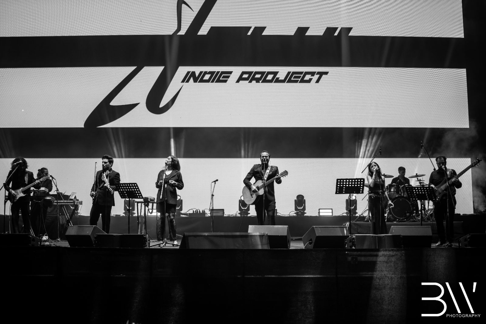 Delhi Indie Project, full band, on a large stage in black and white