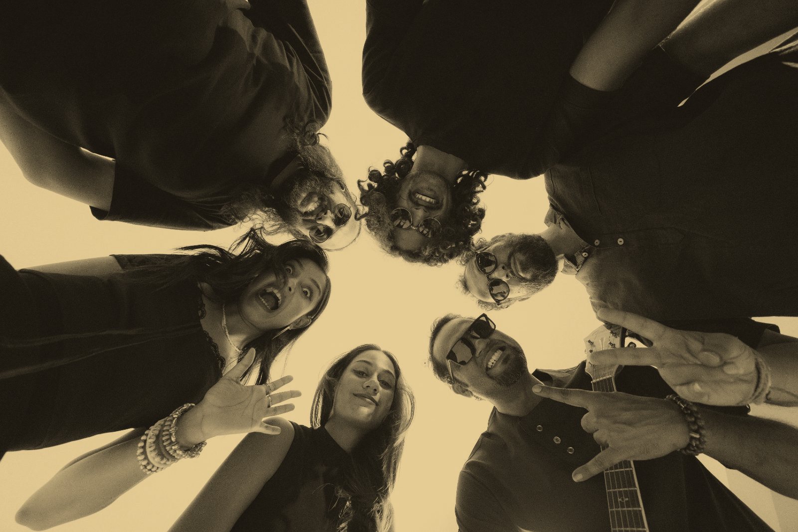 The band in a huddle, photographed from below